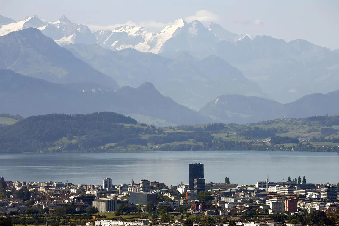 FILE PHOTO: The snow-covered peaks of Bernese Oberland are seen behind Lake Zug and the city of Zug, Switzerland August 20, 2020.  REUTERS/Arnd Wiegmann/File Photo