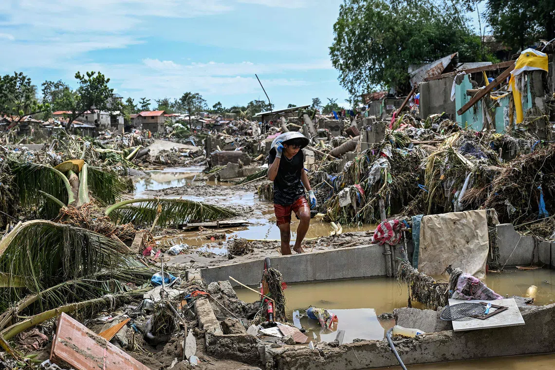 A resident walks along damaged houses in the aftermath of Typhoon Kalmaegi in Talisay, in the province of Cebu, on Nov 5, 2025. 