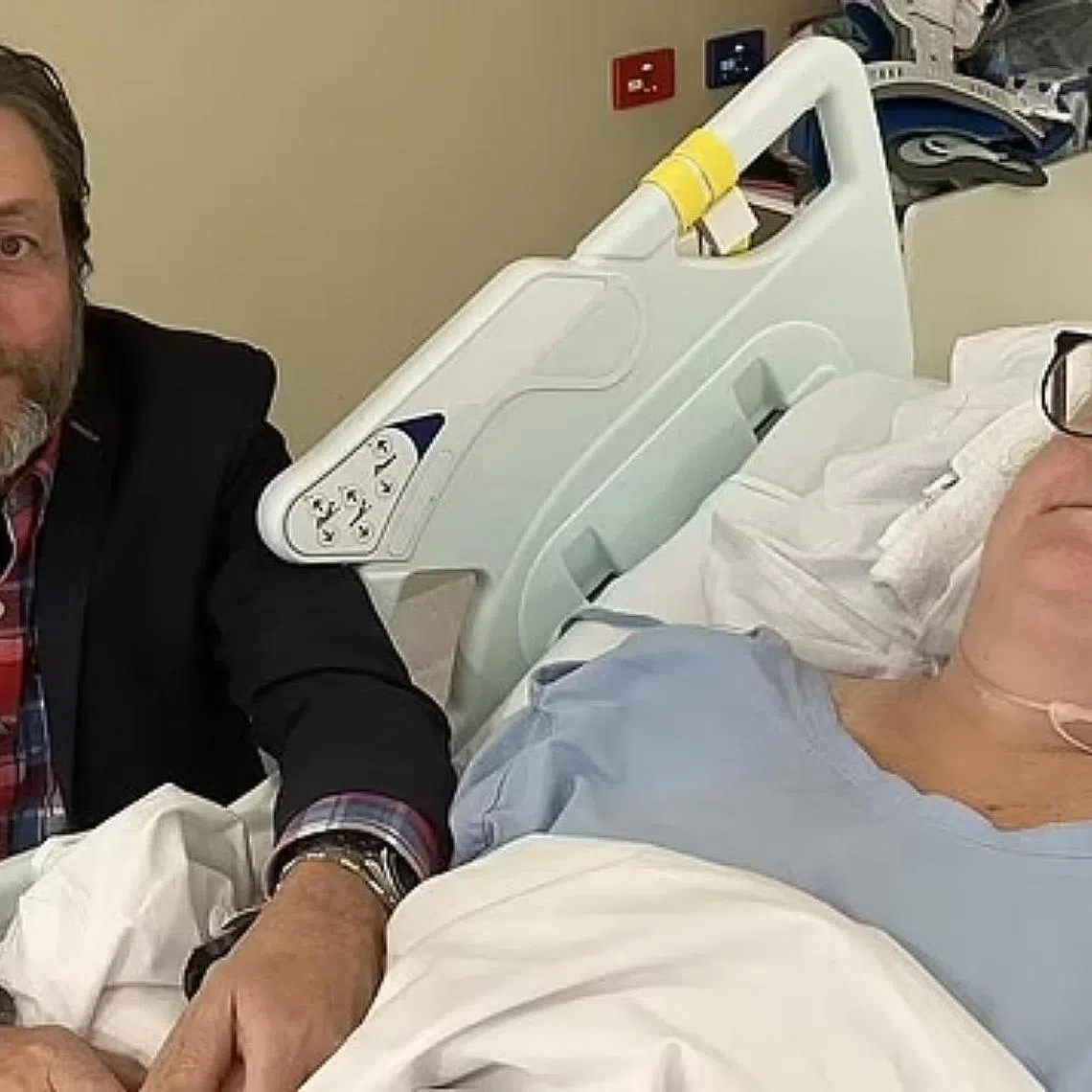 Ms Kerry Jordan is left paralysed from the chest down as a result of a spine injury when Singapore Airlines flight 321 struck turbulence. She is pictured in the hospital with husband Keith Davis.