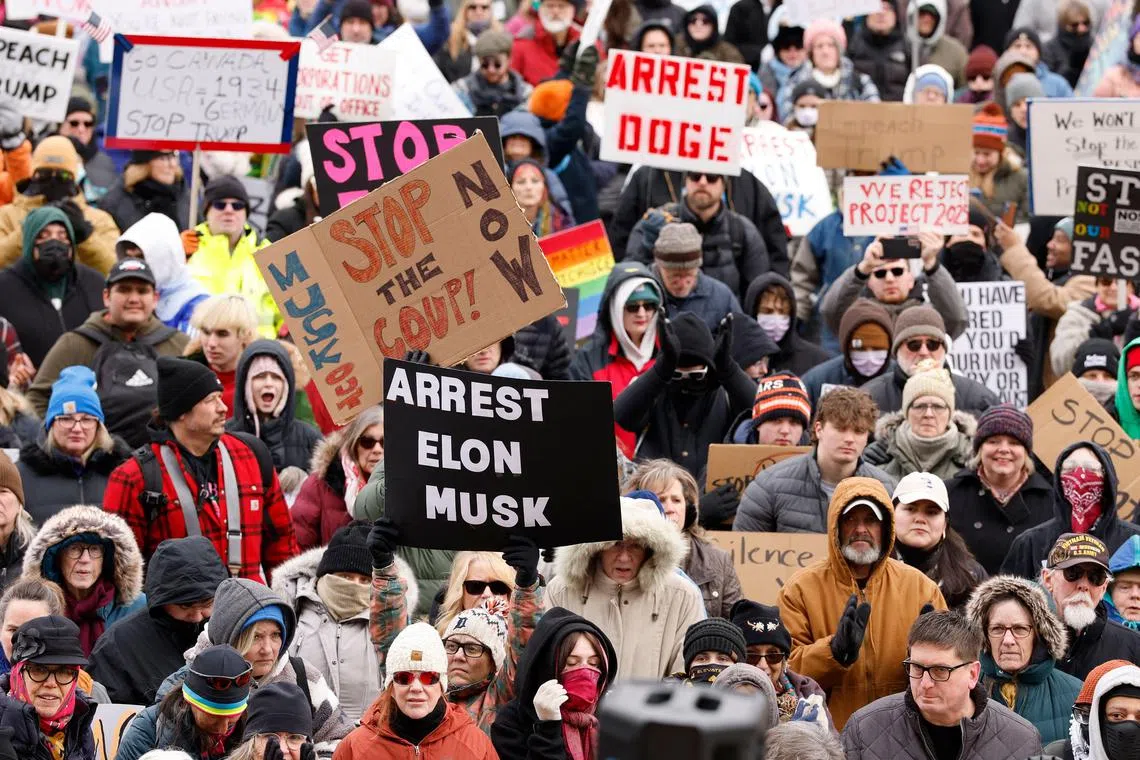 People protesting against US President Donald Trump and Elon Musk outside the Michigan Capitol in Lansing on Feb 5. 