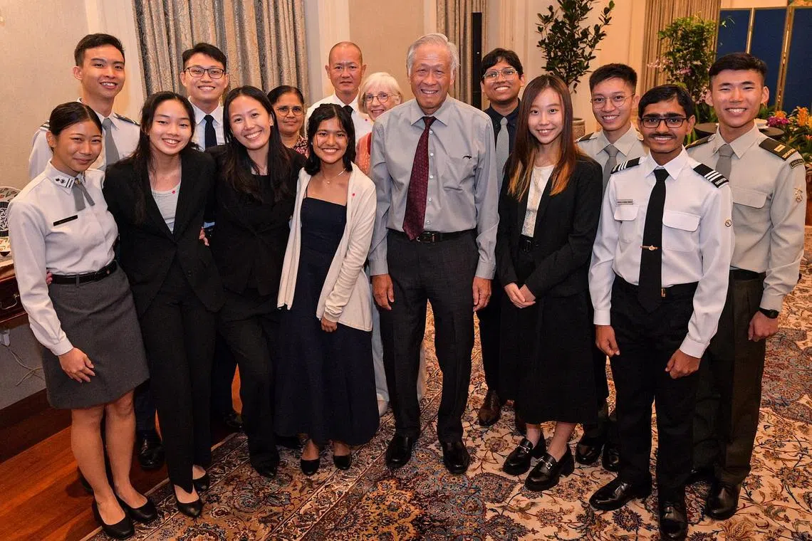 Defence Minister Ng Eng Hen (centre) with some of the defence scholarship recipients and their families at the Istana on Aug 14.