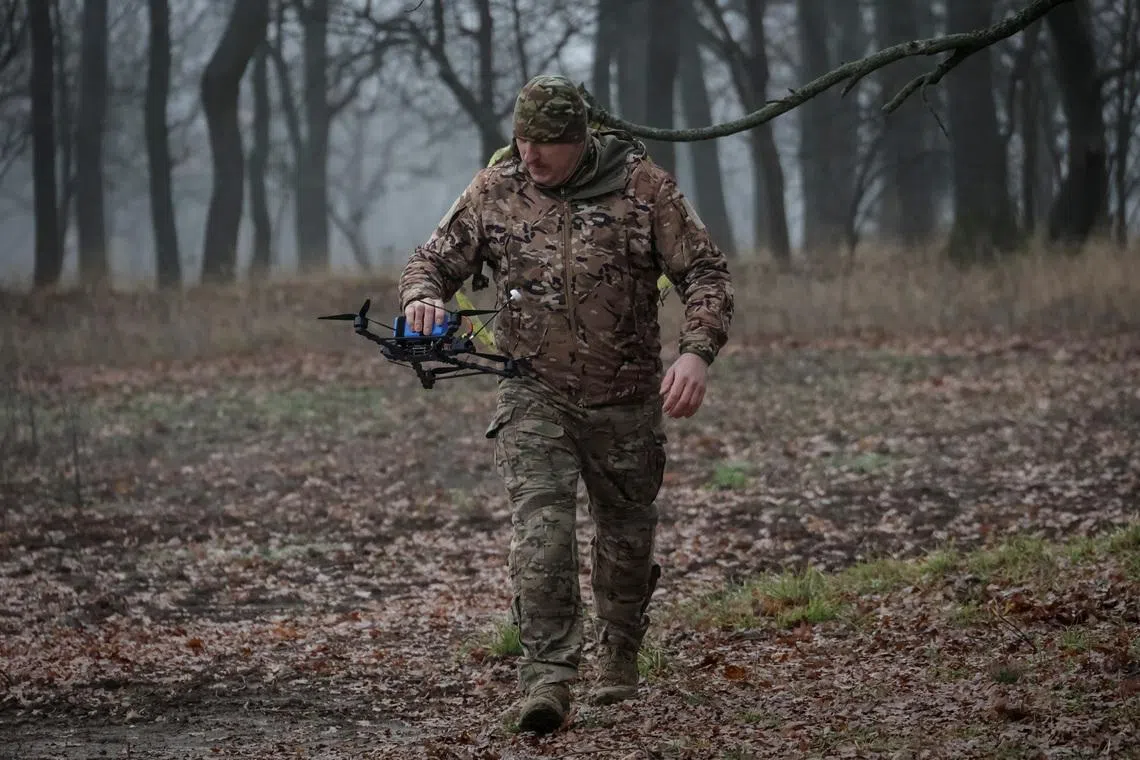 A serviceman of the 58th Separate Motorized Infantry Brigade of the Ukrainian Armed Forces carries a FPV-drone with an AI-assisted targeting system, amid Russia's attack on Ukraine, in Kharkiv region, Ukraine November 26, 2025. REUTERS/Sofiia Gatilova