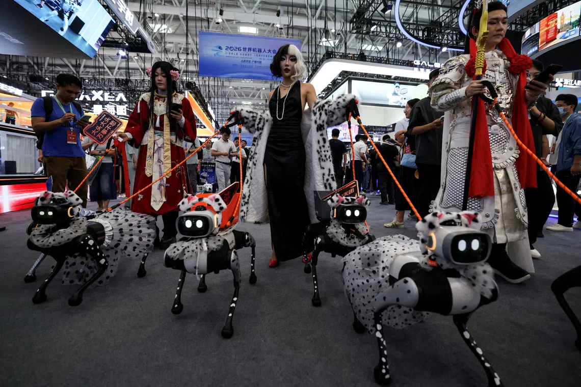A staff member dressed up in a costume walks with VBot robots on a dog leash during the 2026 World Robot Conference, in Beijing, China, August 19, 2026. REUTERS/Tingshu Wang     TPX IMAGES OF THE DAY