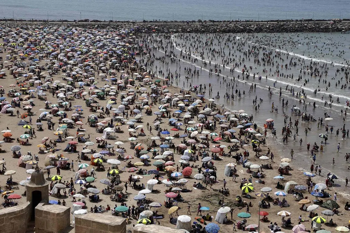 People cooling off at a beach during a heatwave in Rabat on June 29, 2025. Monthly temperature records have been broken across Morocco, sometimes topping seasonal norms by as much as 20 deg C, the national meteorological office said on June 29.