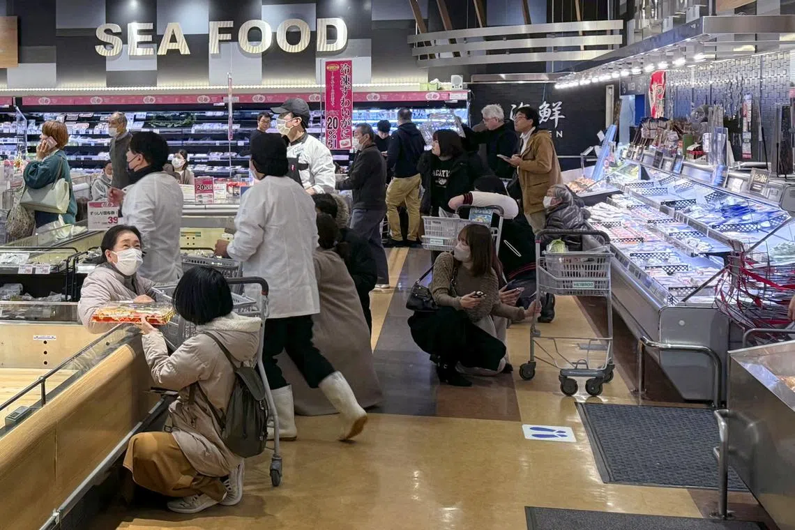 Shoppers at a supermarket crouching down as an earthquake hit the Toyama region, Japan, on Jan 1, 2024.