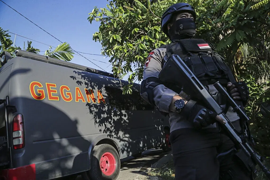 A fully armed police on guard in 2016 in an area leading to the house of a suspected terrorist in Batam, Riau Islands.
