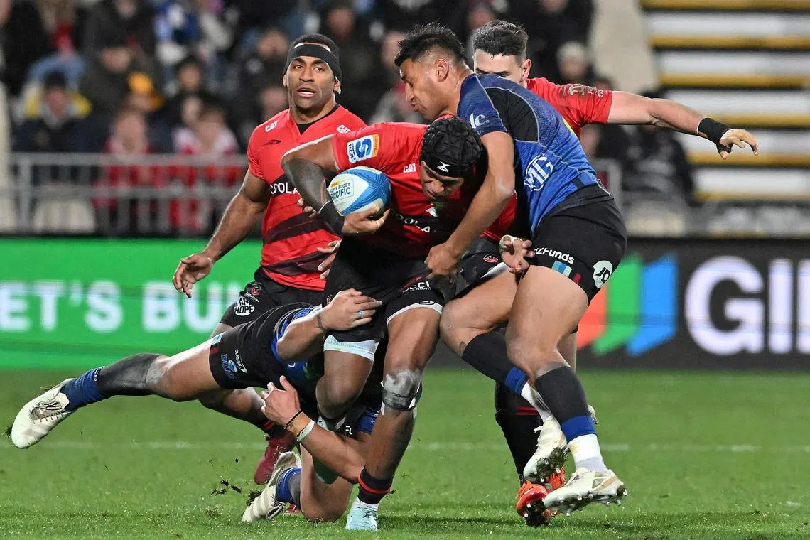 Crusaders' Chay Fihaki is tackled in the Super Rugby Pacific semi-final against the Blues in Christchurch on June 13, 2025.