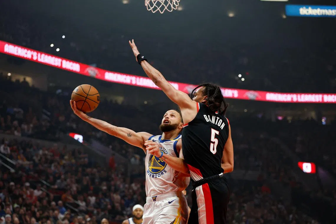 Golden State Warriors' Stephen Curry attempts a shot as the Portland Trail Blazers' Dalano Banton tries to stop him on April 11.