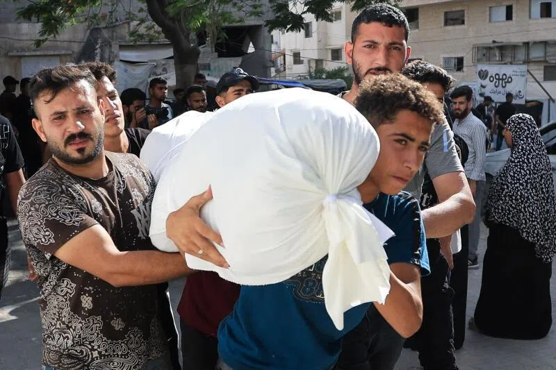 Mourners carry the body of a Palestinian killed in an Israeli strike, according to medics, at Al-Shifa Hospital in Gaza City, on June 14.