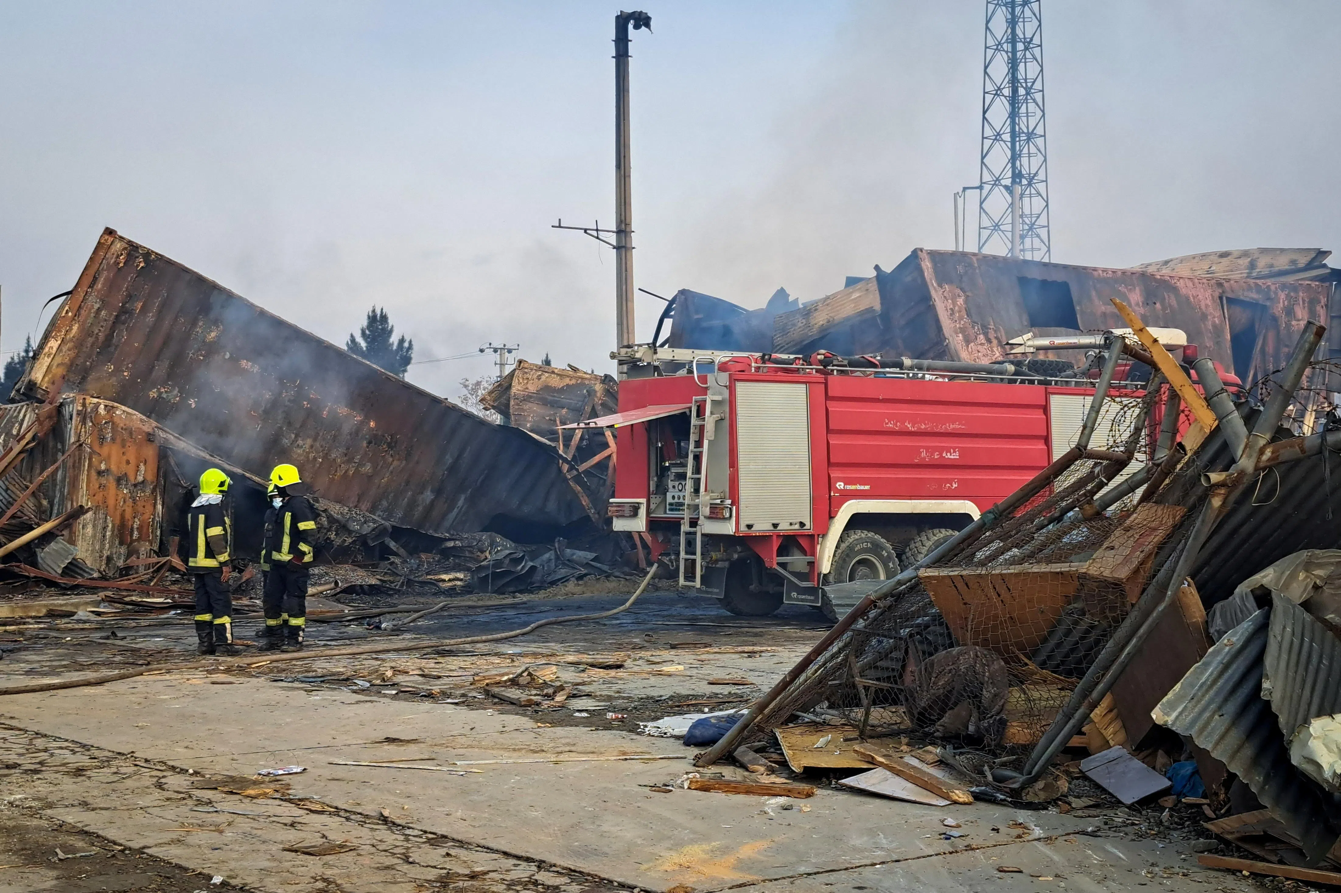 Firefighters stand next to a fire truck at the site of a drug users rehabilitation hospital destroyed in what the Taliban said was a Pakistani air strike in Kabul, Afghanistan, March 17, 2026. REUTERS/Yunus Yawar
