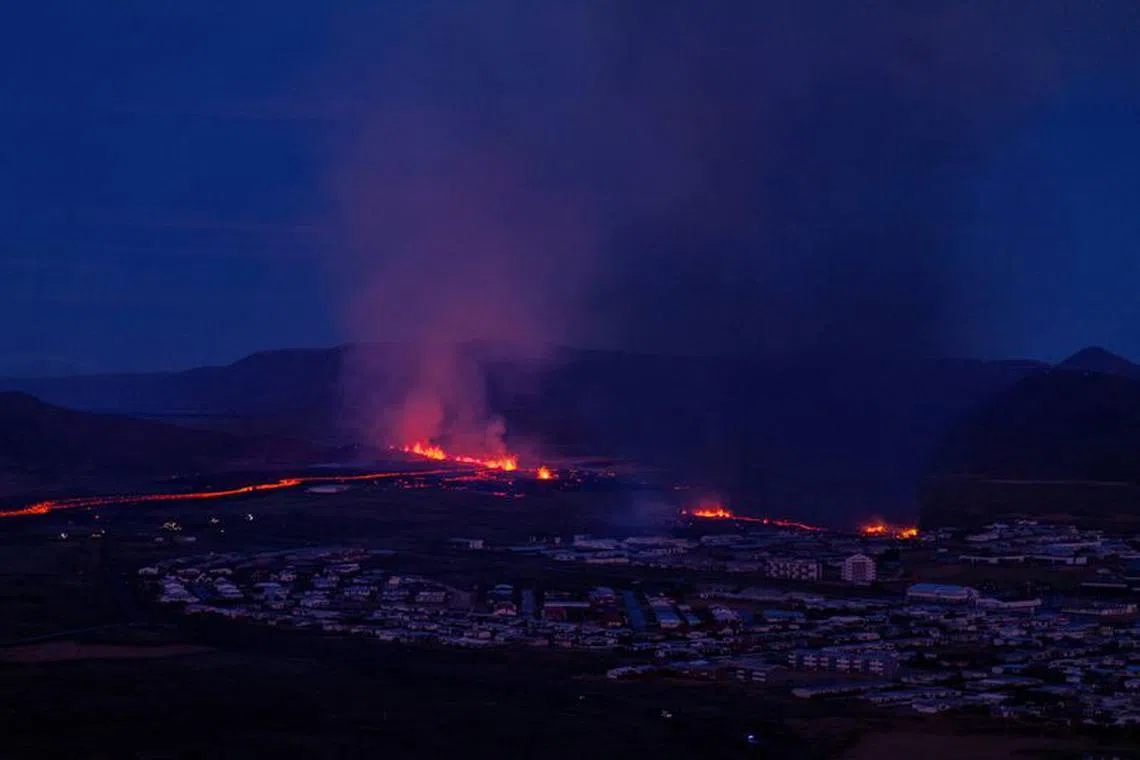 FILE PHOTO: Smoke rises as lava flows from a volcano in Grindavik, Iceland, on January 14, 2024. Icelandic Coast Guard/Handout via REUTERS