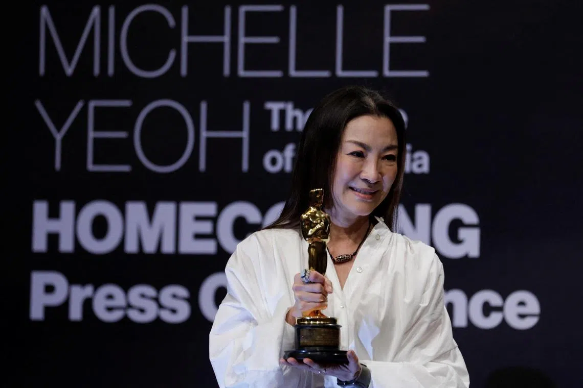 Actress Michelle Yeoh shows her engraved Oscar statuette during a news conference in Kuala Lumpur on Tuesday.
