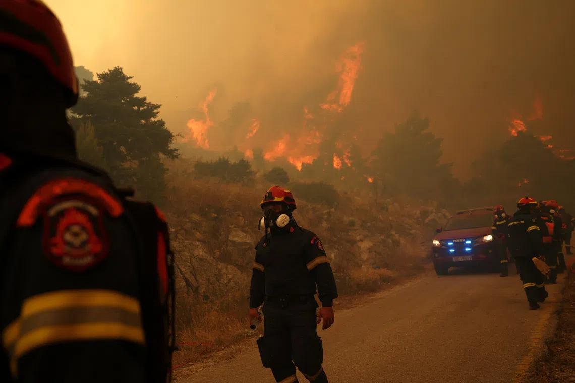 Firefighters work as a wildfire burns on Mount Kithairon, Greece, August 3, 2026. REUTERS/Stelios Misinas