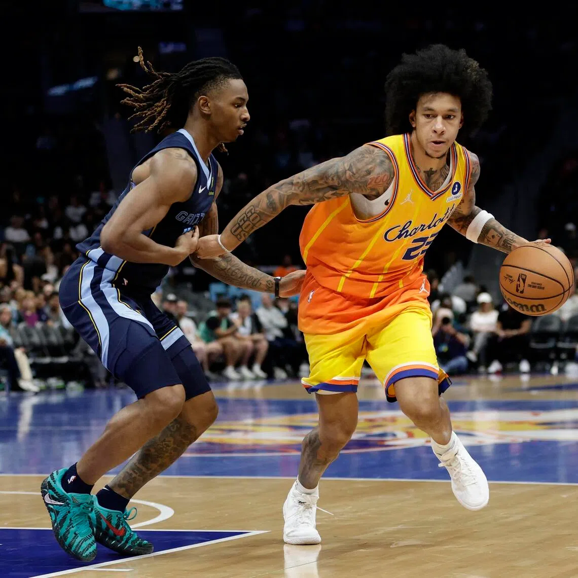 Charlotte Hornets guard Tre Mann keeps the ball away from Memphis Grizzlies guard Javon Small during the fourth quarter at Spectrum Center. 