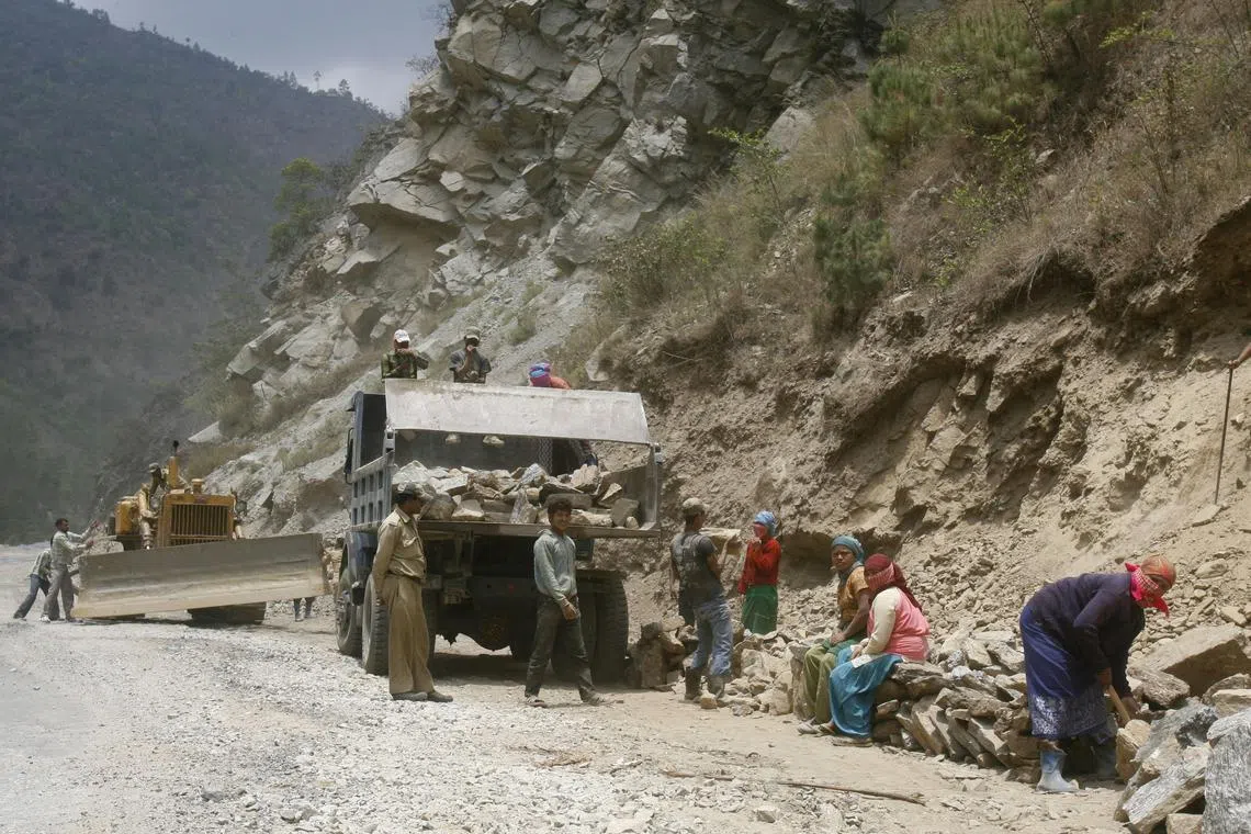 FILE PHOTO: Labourers work on India's Tezpur-Tawang highway which runs to the Chinese border in the northeastern Indian state of Arunachal Pradesh. May 28, 2012. REUTERS/Frank Jack Daniel/File Photo
