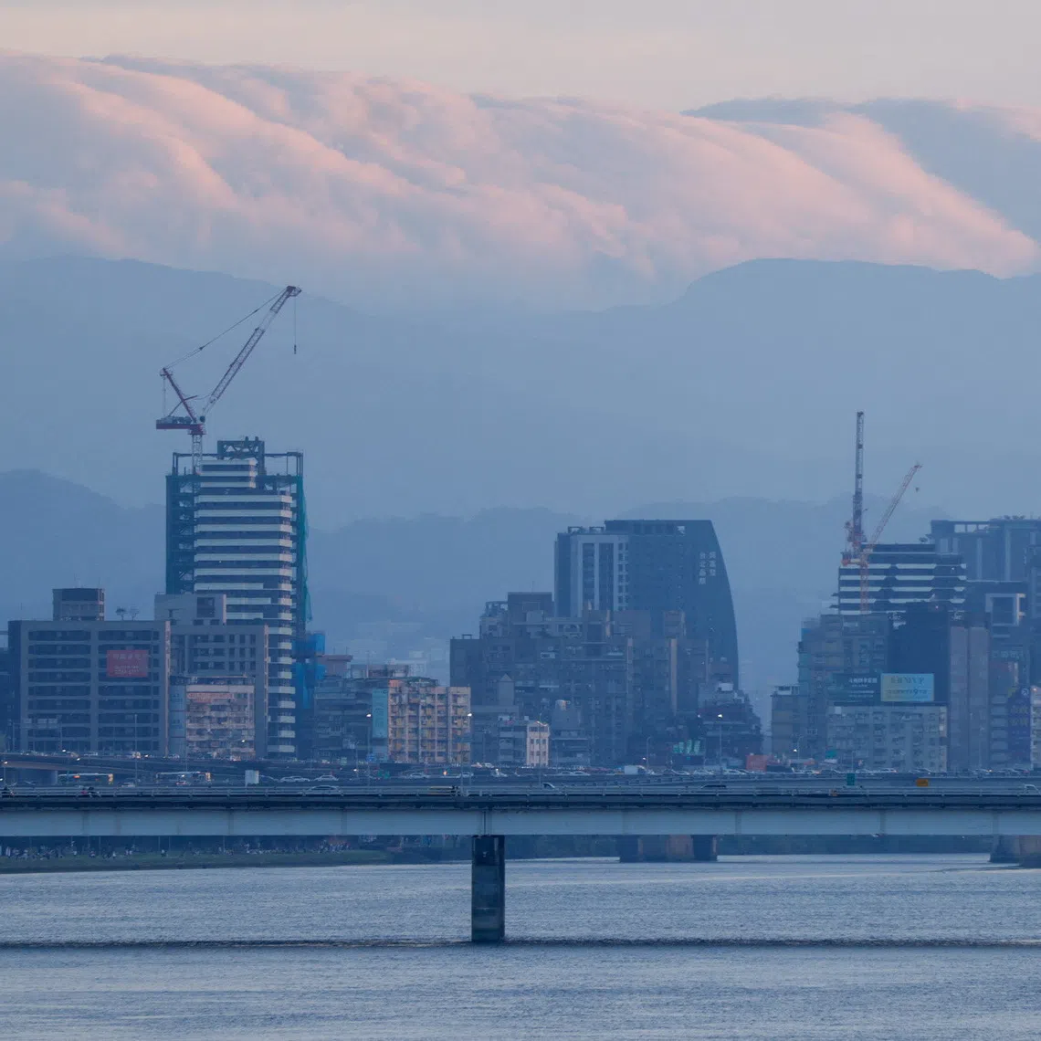 A view of the Taipei skyline with clouds hanging over distant mountains, seen from across the Tamsui River in Taipei, Taiwan, November 8, 2025. REUTERS/Ann Wang