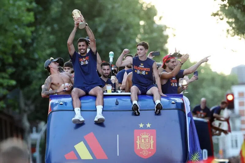 Spain’s midfielder Rodri holds their trophy as Spain’s players parade onboard an open-top bus through the streets of Madrid on July 20.