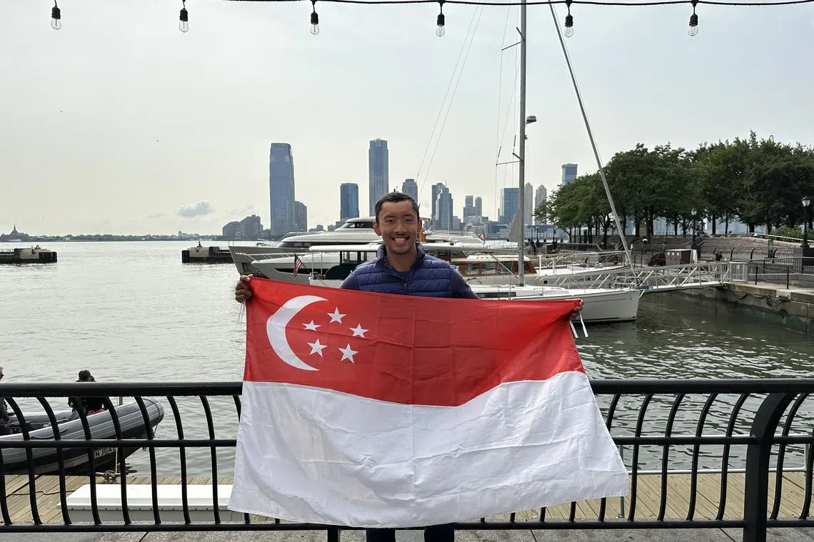 Dr Chua Jia Long holding the Singapore flag after completing the 8 Bridges Hudson River Swim on Friday. [Confirming caption]
