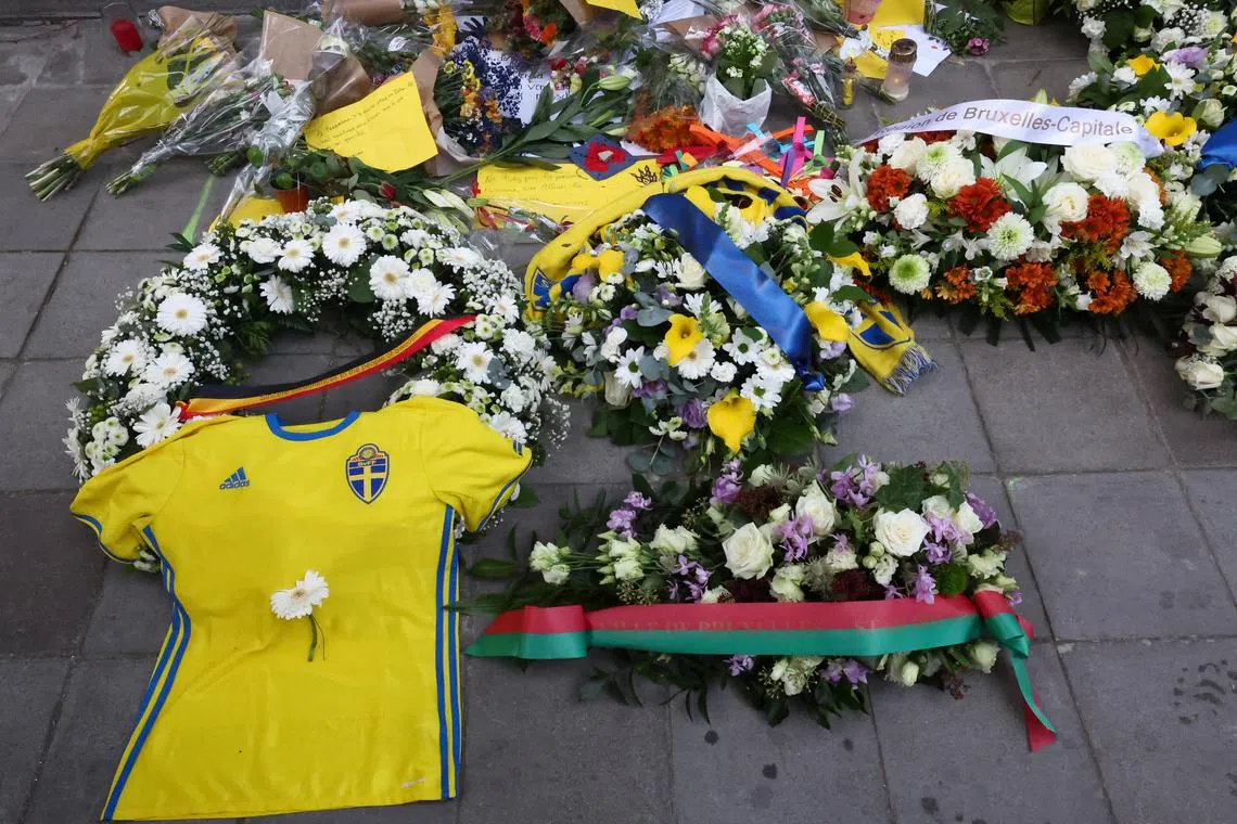 FILE PHOTO: Flowers placed by Swedish Prime Minister Ulf Kristersson and Belgian Prime Minister Alexander De Croo are seen among other items left as a tribute to the victims two days after a gunman shot dead two Swedes, at the place of the shooting in Brussels, Belgium October 18, 2023. REUTERS/Yves Herman/File Photo