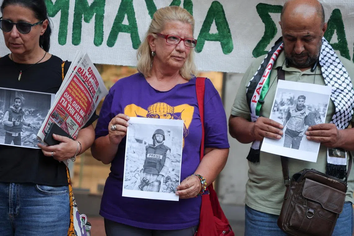 Greek and foreign journalists hold pictures of recently killed journalists in Gaza, during a protest outside the Union of Greek Journalists in Athens, Greece, September 4, 2025. REUTERS/Louisa Gouliamaki