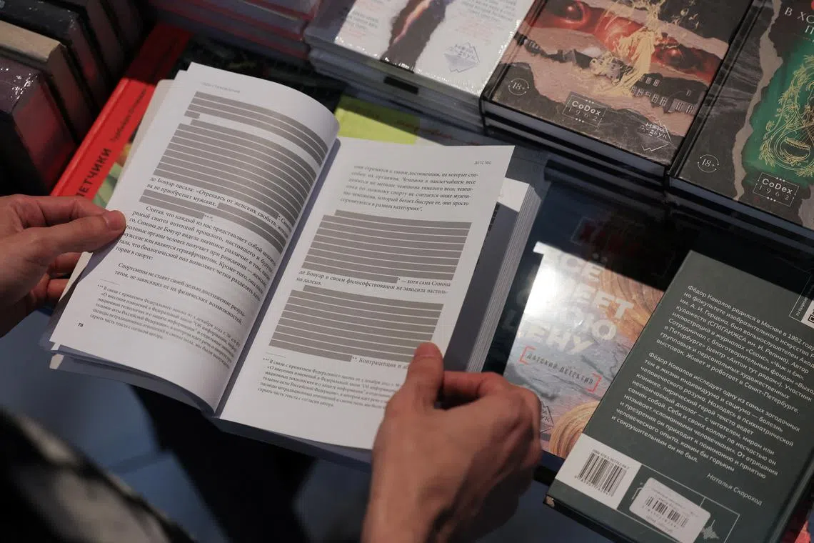 An employee shows the censored edition of the book \"How to Be Authentic: Simone de Beauvoir and the Quest for Fulfillment\" by Skye Cleary in the \"Vo ves golos\" (At the top of my voice) bookstore in Saint Petersburg, Russia September 1, 2025.  REUTERS/Anton Vaganov