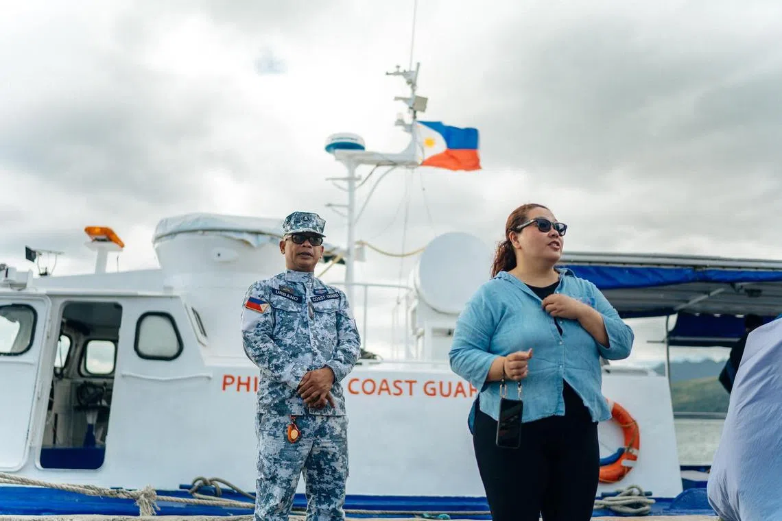 Filipino filmmaker Baby Ruth Villarama stands in front of a Philippine Coast Guard ship while shooting her documentary on the South China Sea.  