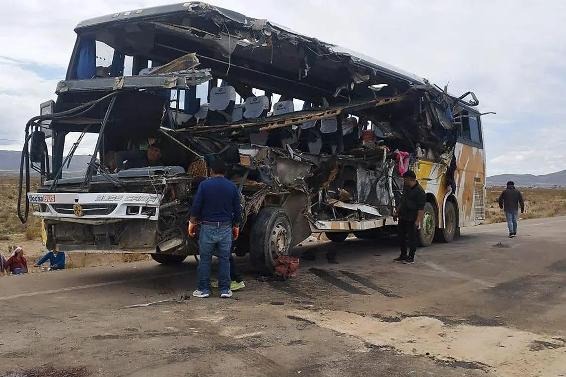 People checking the wreckage of a bus that collided with another one on a highway near Uyuni, Bolivia, on March 1.