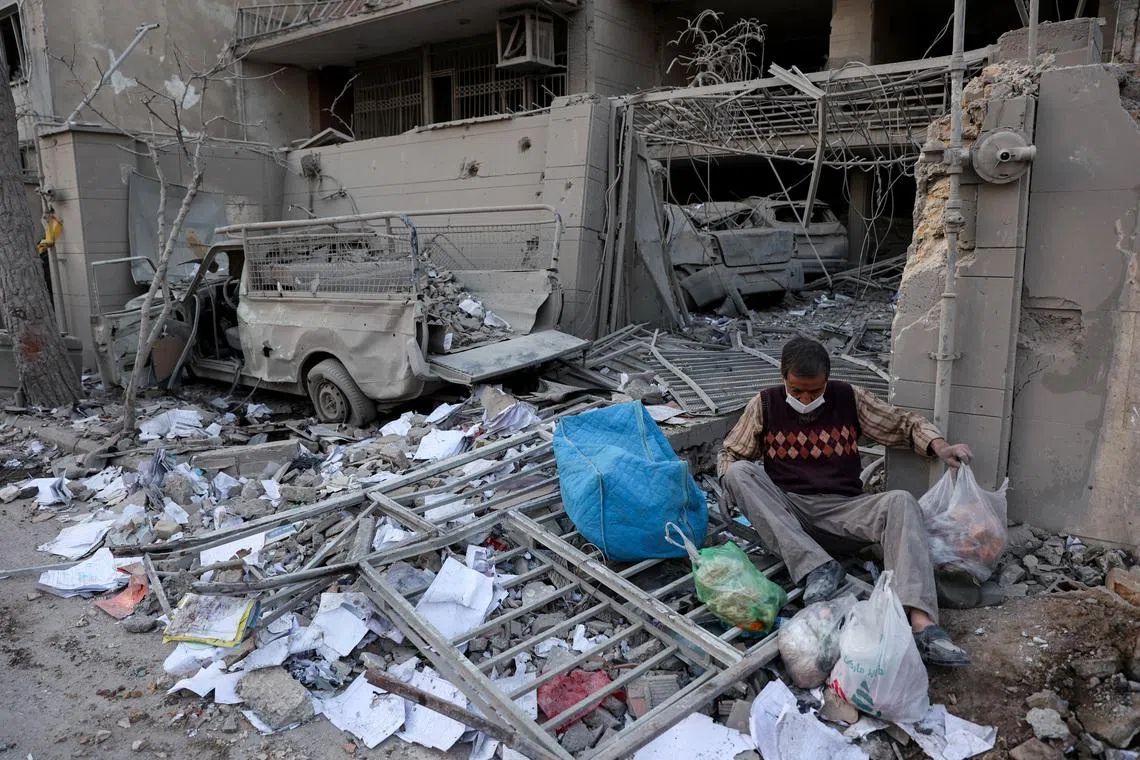 A person sits amid debris following an Israeli and U.S. strike on a police station, amid the U.S.-Israel conflict with Iran, in Tehran, Iran, March 2, 2026. Majid Asgaripour/WANA (West Asia News Agency) via REUTERS