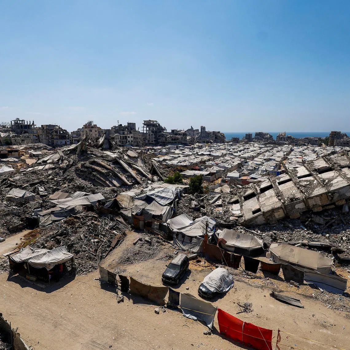 A general view of the rubble of residential buildings destroyed during the Israeli offensive and tents sheltering displaced Palestinians in Gaza City, July 4, 2026. REUTERS/Mahmoud Issa