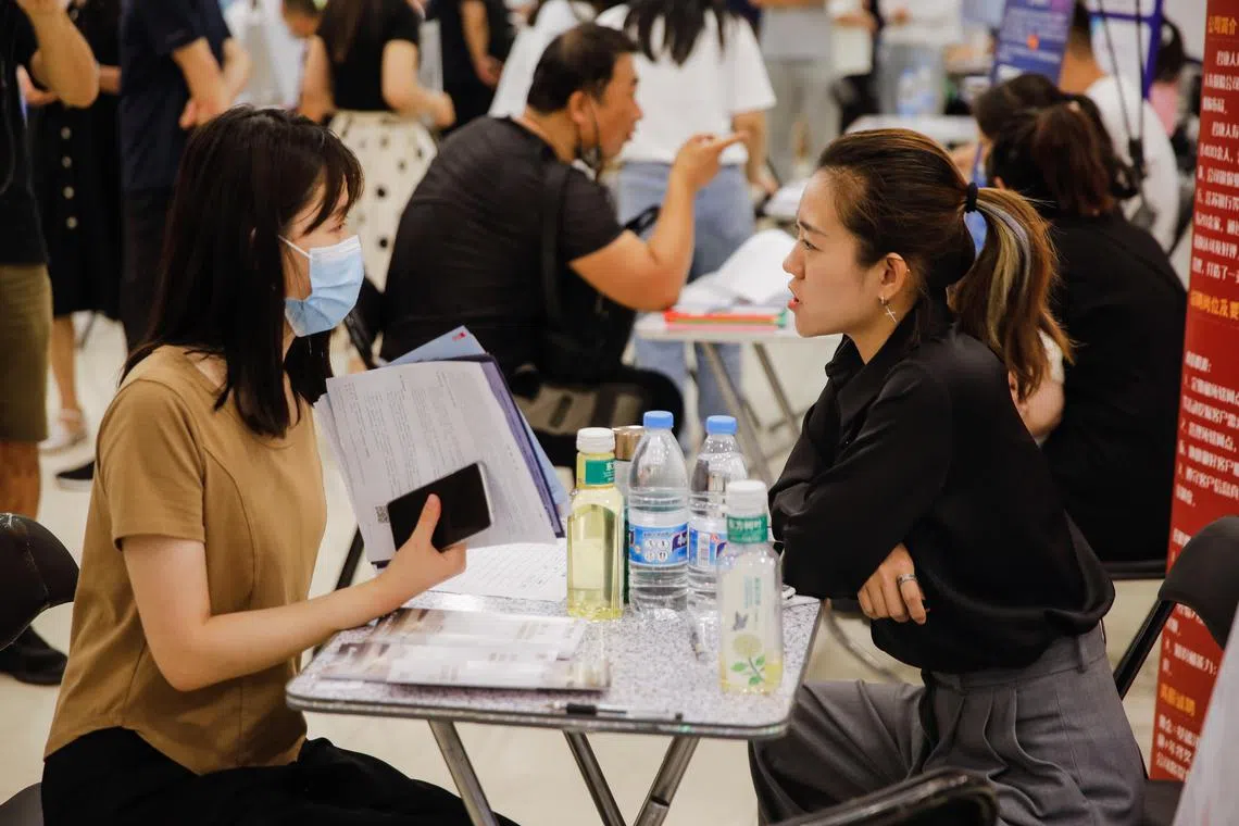A job seeker and recruiter interact at a job fair in Beijing on June 9, 2023. 