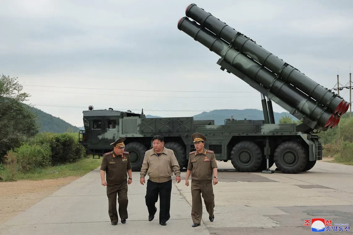 North Korean leader Kim Jong Un (centre) inspects a test firing of a new-type 600mm multiple rocket launcher at an undisclosed location in North Korea. 