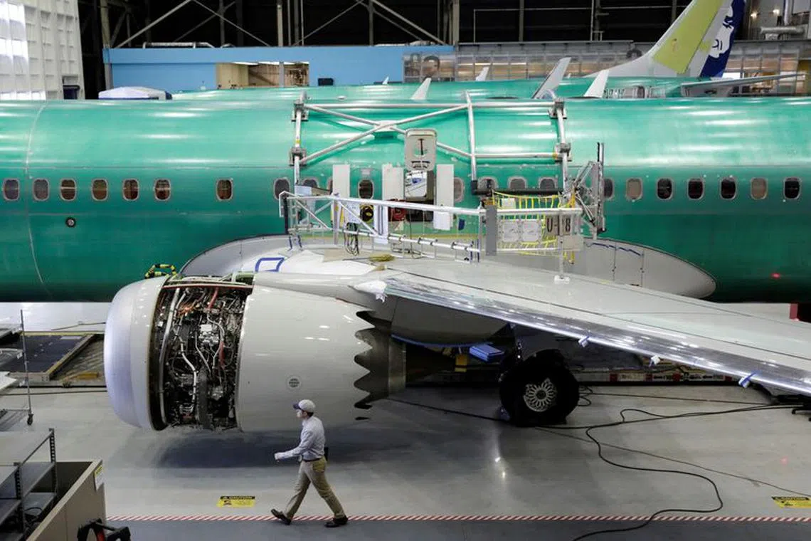 FILE PHOTO: A worker walks past Boeing's new 737 MAX-9 under construction at their production facility in Renton, Washington, U.S., February 13, 2017. Picture taken February 13, 2017. REUTERS/Jason Redmond/File Photo