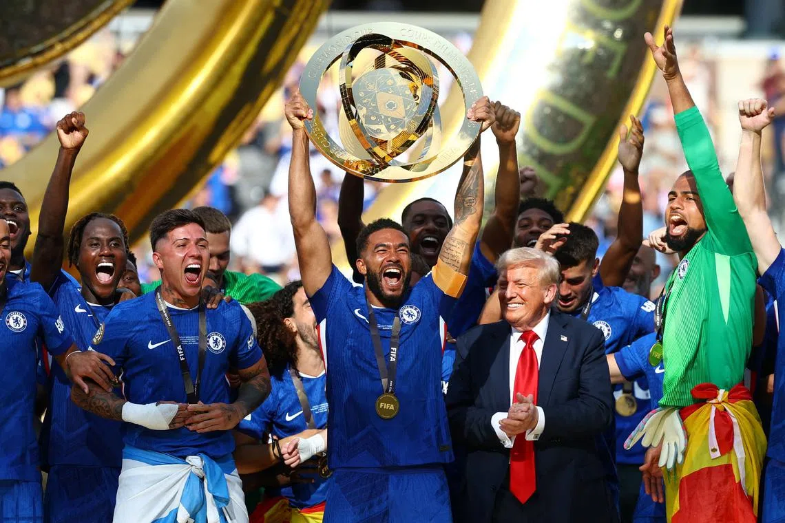 Soccer Football - FIFA Club World Cup - Final - Chelsea v Paris St Germain - MetLife Stadium, East Rutherford, New Jersey, U.S. - July 13, 2025 Chelsea's Reece James lifts the trophy as he celebrates with teammates after winning the FIFA Club World Cup, U.S. President Donald Trump looks on REUTERS/Kai Pfaffenbach