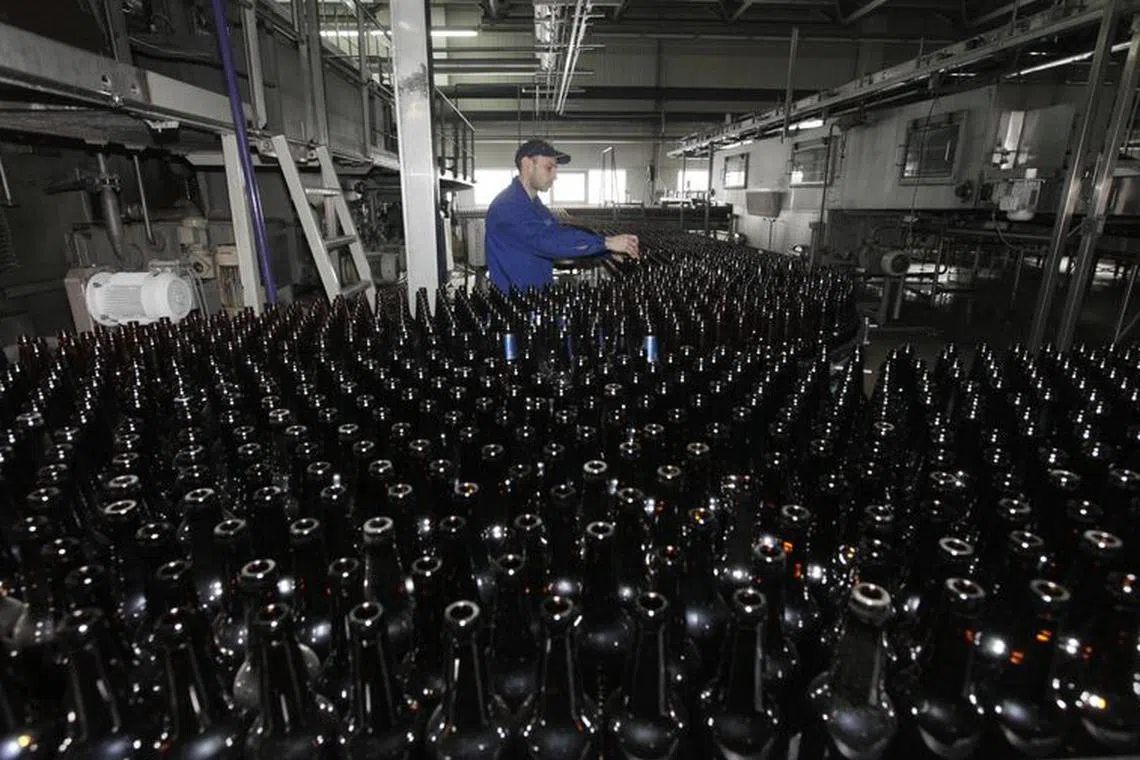 FILE PHOTO: An employee works at a line bottling beer at Carlsberg brewery \"Baltika-Pikra\" factory in Krasnoyarsk, January 10, 2013. REUTERS/Ilya Naymushin/File photo