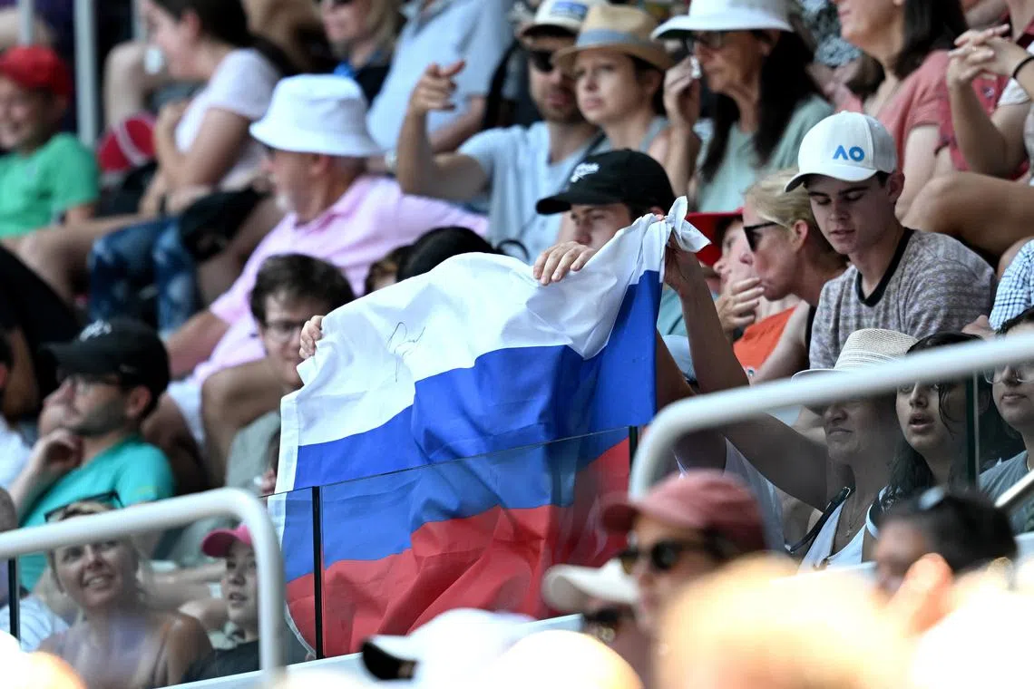 A Russian flag is displayed by spectators during the first-round match between Andrey Rublev and Dominic Thiem at the Australian Open on Jan 17.