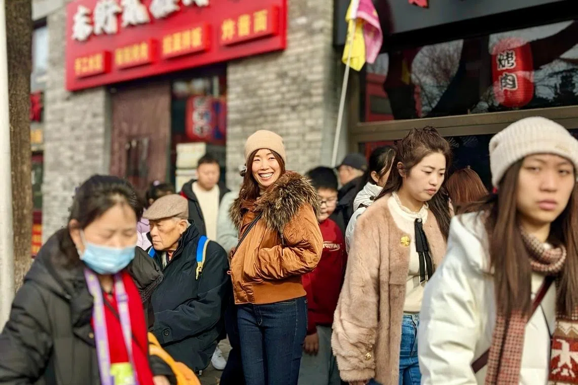 The writer (centre) on a busy street in Beijing.
