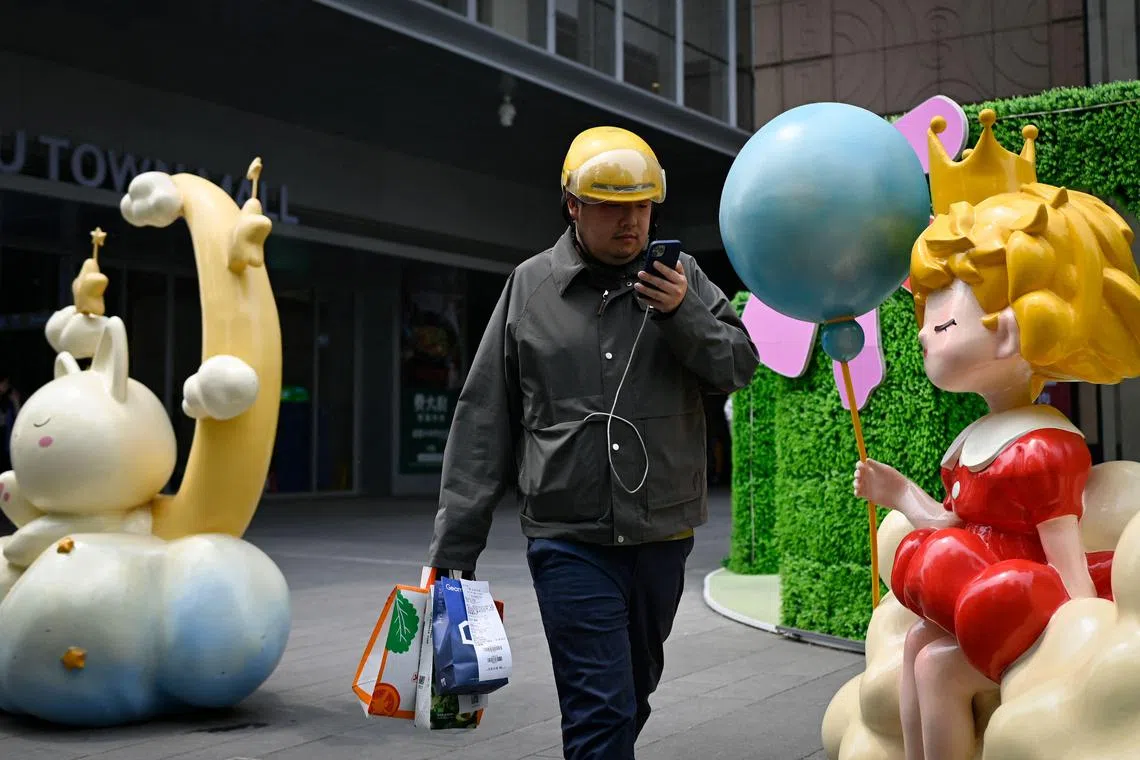 A food delivery worker walks out of a mall in Beijing on May 8, 2025. 