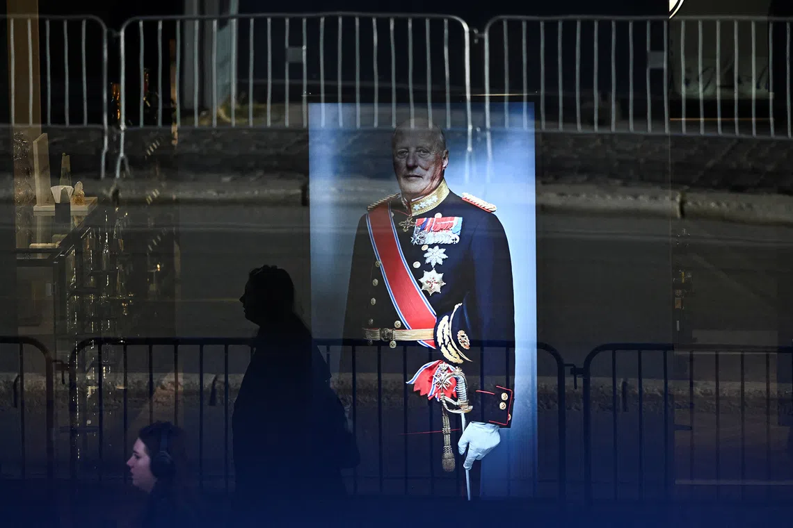 A woman walks past a window of a building displaying a picture of Norway's King Harald ahead of his funeral at Oslo Cathedral in Oslo, Norway, September 9, 2026. REUTERS/Dylan Martinez