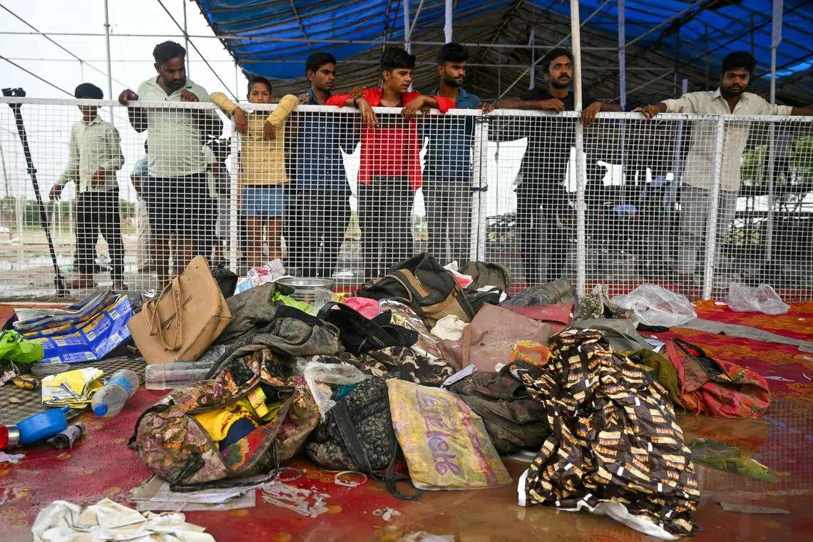 Men look at the stampede site that killed people during a sermon at Hathras in India's Uttar Pradesh state on July 3, 2024. Survivors of India's deadliest stampede in over a decade on July 3 recalled the horror of being crushed at a vastly overcrowded Hindu religious gathering that left 116 people dead. (Photo by Arun SANKAR / AFP)