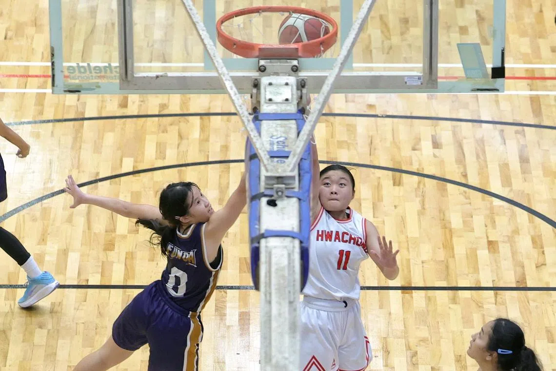 Eunoia Junior College's Gweneth Low (left) attempting to block a layup by Hwa Chong Institution's Eda Kong (right) in the National School Games A Div Girls' basketball final at Jurong East Sports Hall on May 23, 2025.