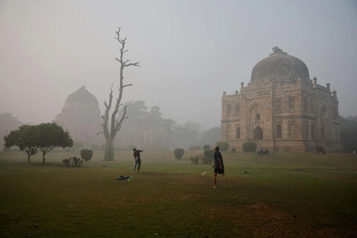 Men play badminton at Lodhi Garden in New Delhi amid smoggy conditions. 