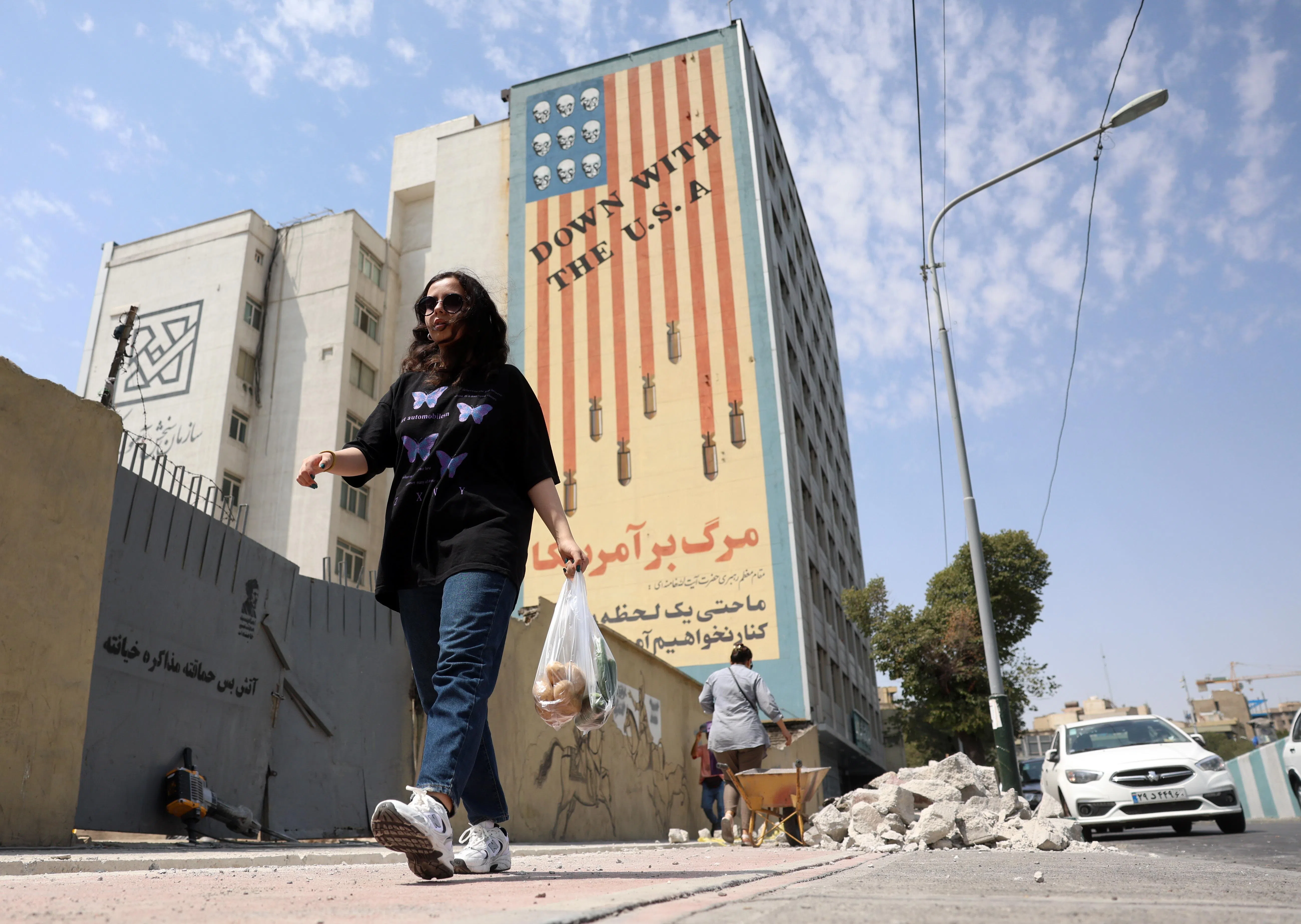 epa13175348 An Iranian woman walks past an anti-US mural in Tehran, Iran, 17 August 2026. Iranian Army chief Amir Hatami announced a 30,000 US dollar bounty for killing or capturing US military personnel, offering double the reward for Iranian women who carry out the action, according to Iranian state media.  EPA/ABEDIN TAHERKENAREH RESTRICTIONS: NO Access Israel Media/Persian Language TV Stations Outside Iran/Strictly No Access BBC Persian/VOA Persian/Manoto TV/Iran International TV. (As mandated by Iran's Directorate General for Foreign Media) --