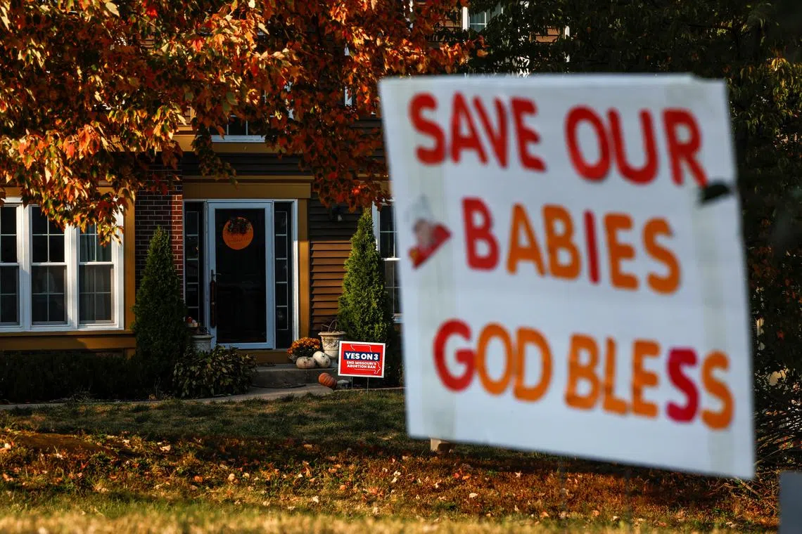 Competing yard signs for and against Amendment 3, a measure that would establish a constitutional right to abortion dot neighborhoods in Kansas City, Missouri, U.S., October 11, 2024. REUTERS/Evelyn Hockstein/File Photo