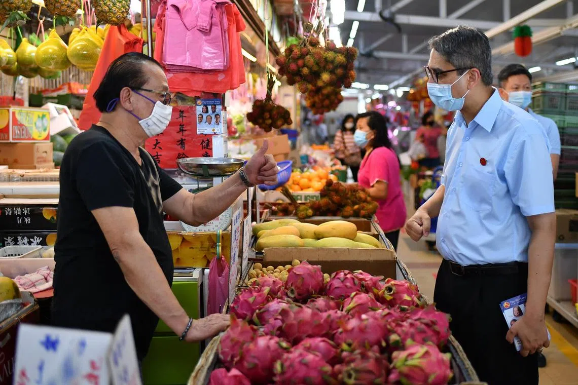 Mr Leon Perera (right), then a candidate for Aljunied GRC, during a walkabout at Kovan Market on July 2, 2020. 
