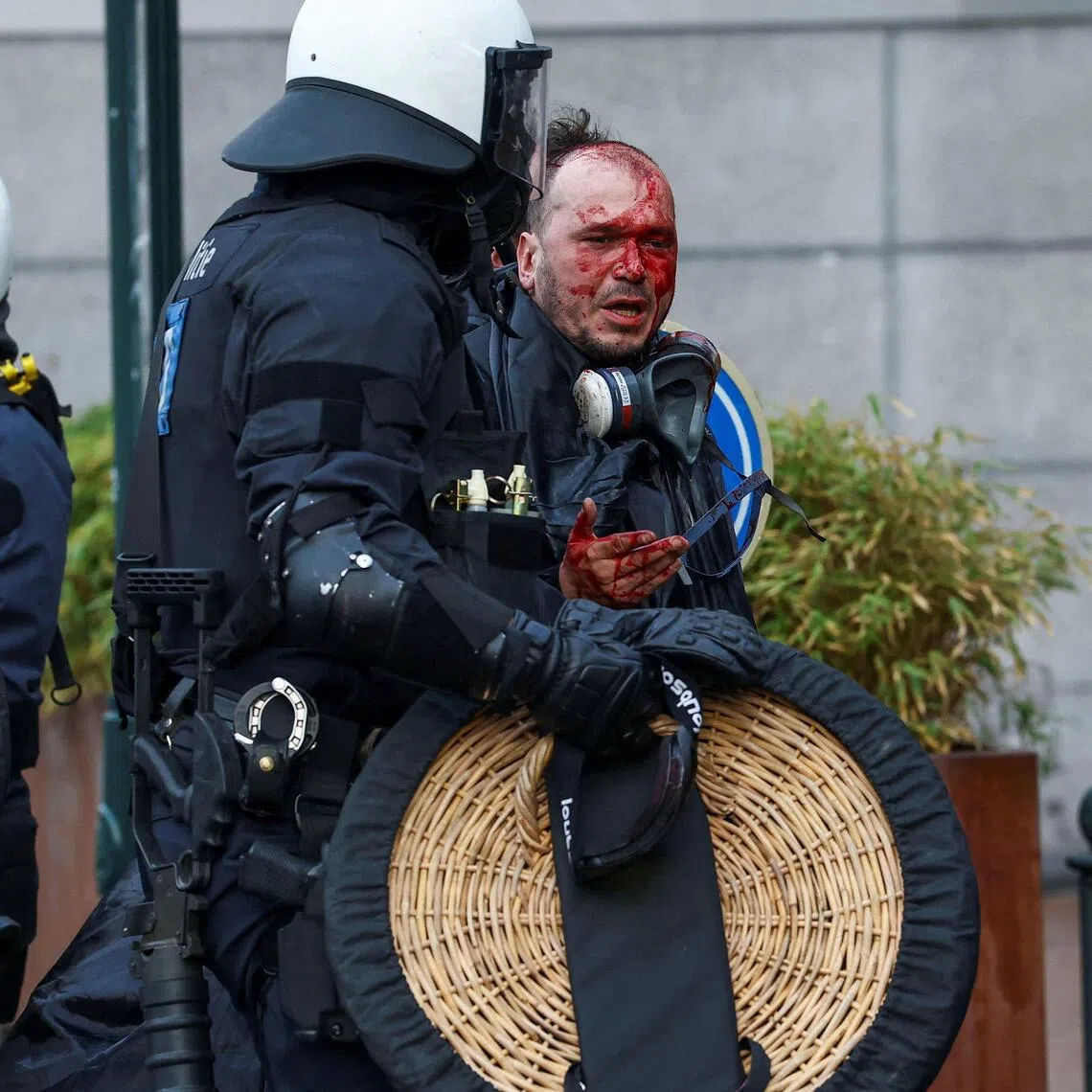 A police officer walking with a wounded man, during protests by farmers in Brussels  on Dec 18 against the EU-Mercosur free-trade deal between the EU and the South American countries of Argentina, Brazil, Paraguay and Uruguay. 