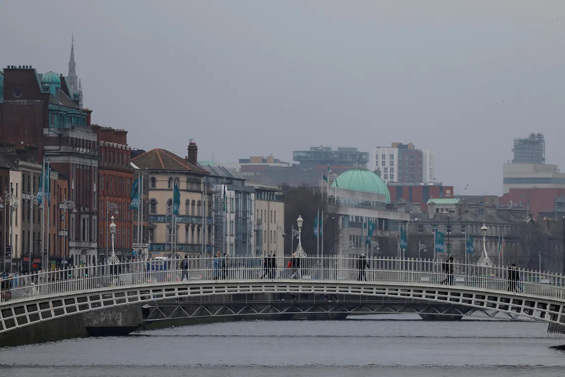 People walk on the Ha’penny Bridge, in Dublin, Ireland, February 18, 2025. REUTERS/Clodagh Kilcoyne
