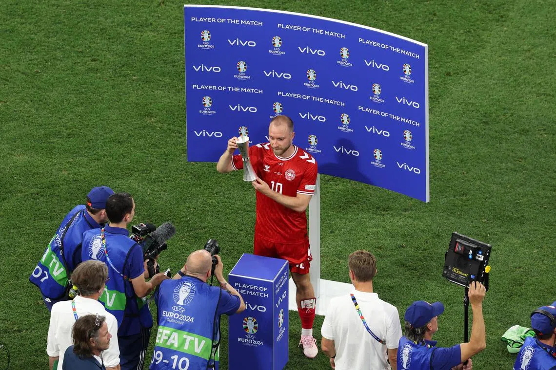 Christian Eriksen of Denmark poses with the player of the match trophy after the 0-0 draw with Serbia.
