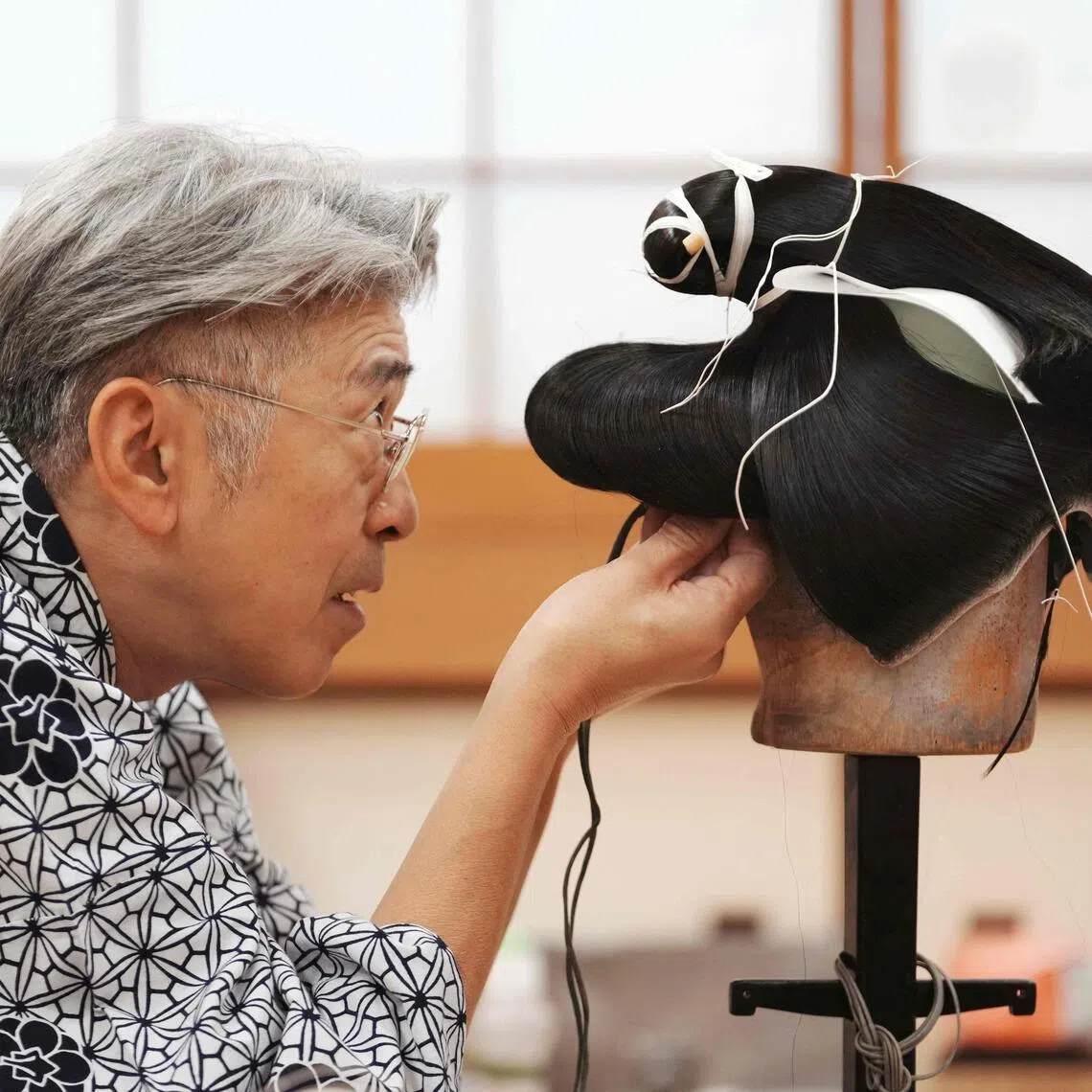 Wig master Tadashi Kamoji creating a wig for kabuki actors at his atelier in Tokyo, on March 11.