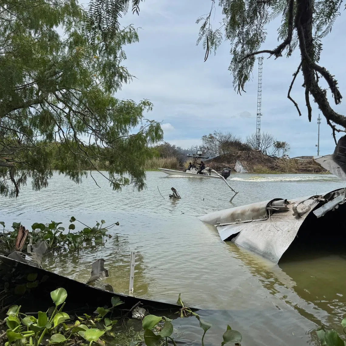 FILE PHOTO: Debris from a SpaceX spacecraft lies partially submerged in the Rio Grande River as a boat navigates nearby, as seen from Matamoros, Mexico, June 19, 2025. REUTERS/Abraham Pineda/File Photo