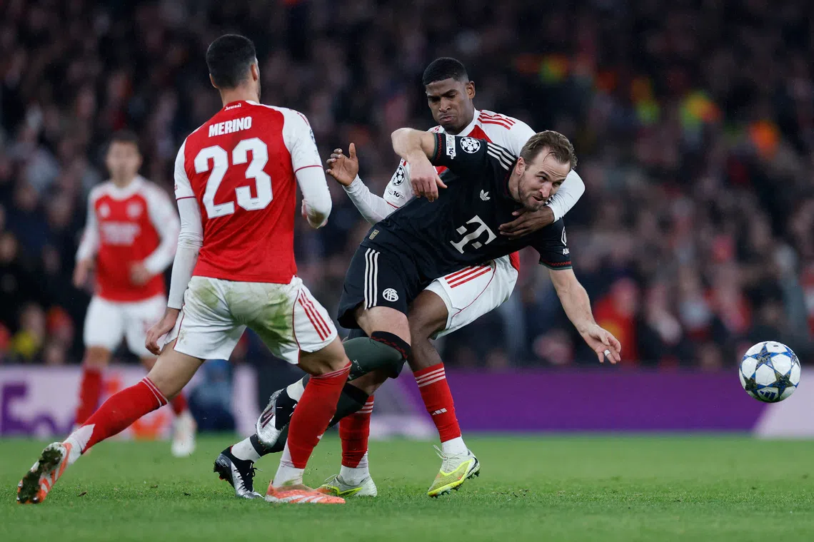 Soccer Football - UEFA Champions League - Arsenal v Bayern Munich - Emirates Stadium, London, Britain - November 26, 2025 Bayern Munich's Harry Kane in action with Arsenal's Cristhian Mosquera and Mikel Merino Action Images via Reuters/Peter Cziborra